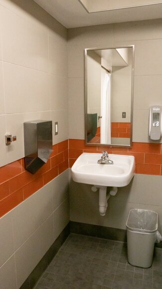 Single occupancy restroom with sink, hand dryer and trashcan
