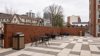 Sherman courtyard with wrought iron chairs and tables and trashcan