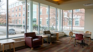 Main Lounge with chairs, tables and large windows looking onto Ikenberry Commons