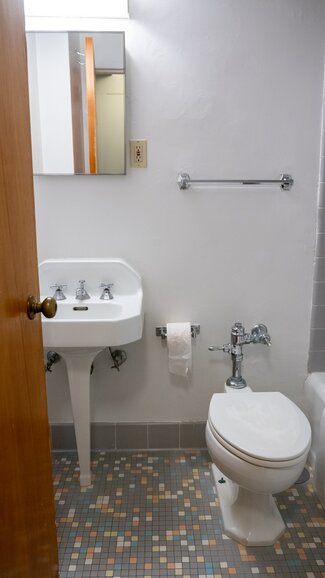 Bathroom with toilet, sink, and towel rack