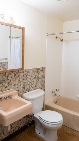Bathroom with tub/shower combo, sink, toilet, mirror