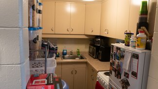 Kitchen with fridge, stove, sink, cabinets and various goods