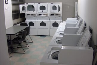 Laundry room with washers, dryers, table and chairs